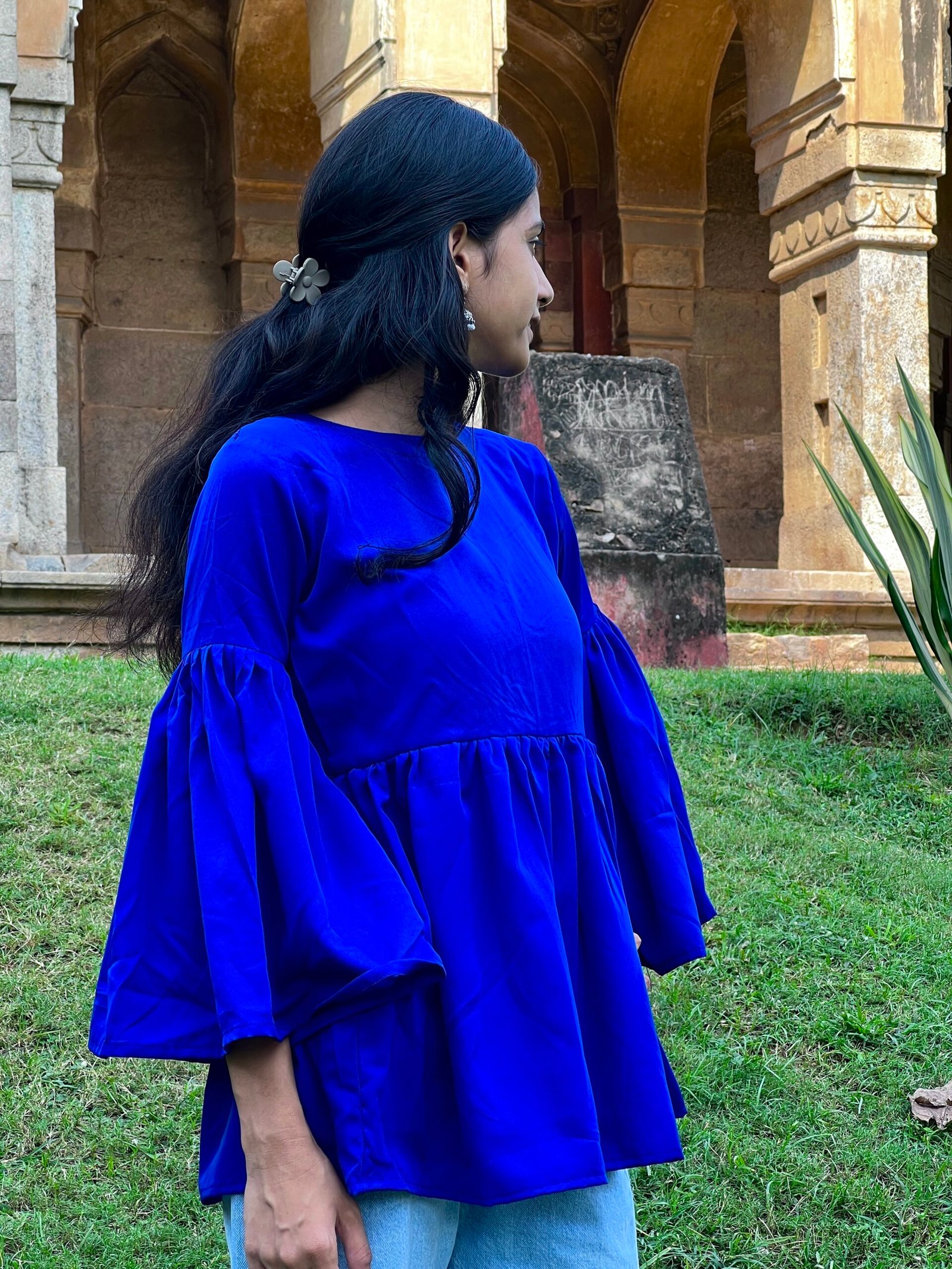 Woman wearing a royal blue short kurti with flared sleeves and a gathered waist