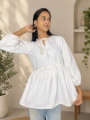 Women's white tunic top with flared hem and long puff sleeves
